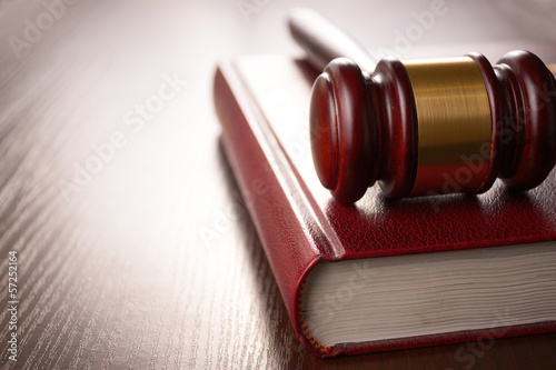 Wooden judges gavel lying on a law book in a courtroom for 
