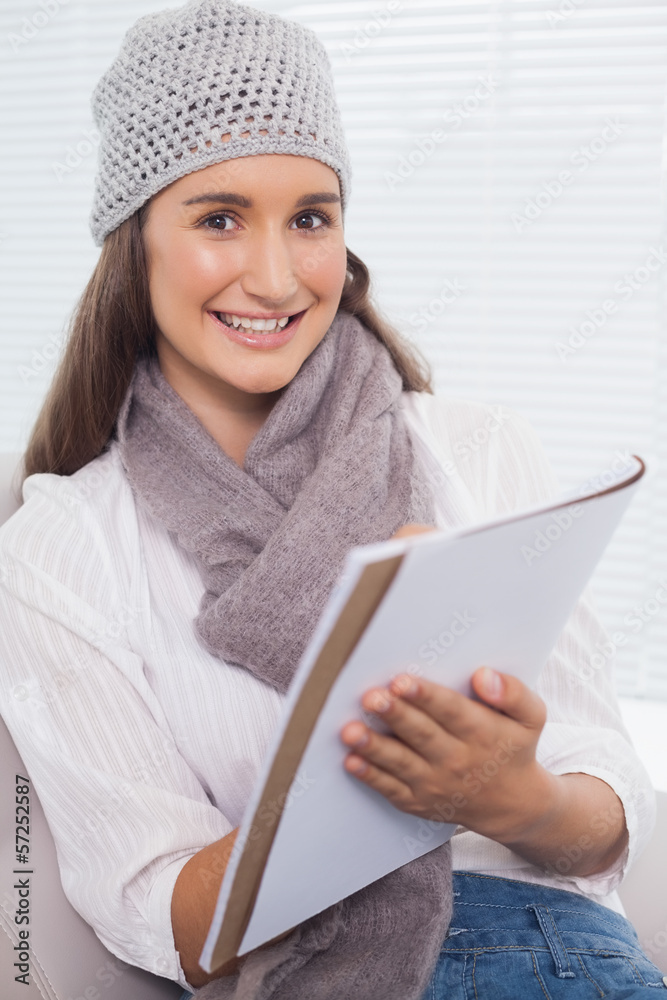 Cheerful brunette with winter hat on writing Cheerful brunette with winter hat on writing