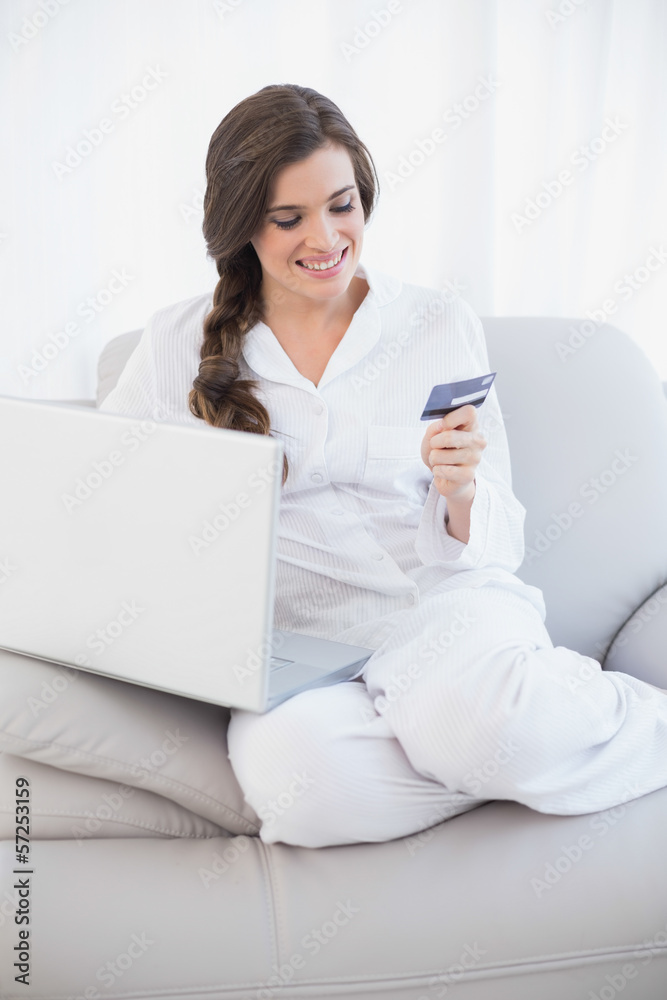 Attractive casual brown haired woman in white pajamas shopping o Attractive casual brown haired woman in white pajamas shopping o