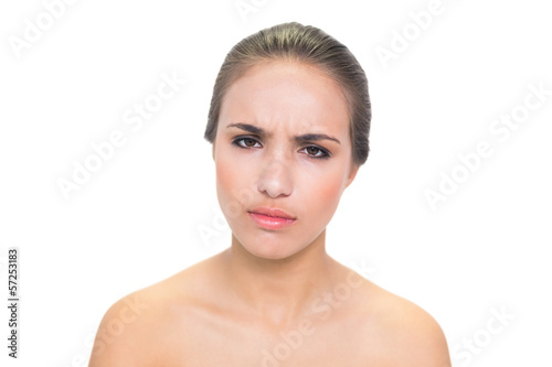 Upset young brunette woman looking at camera