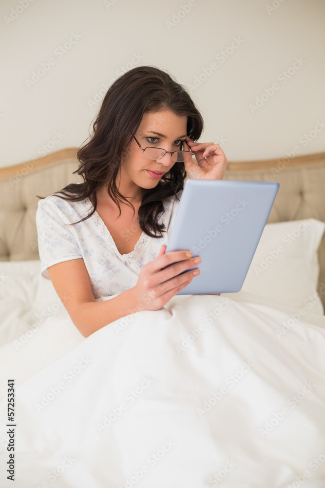 Unsmiling pretty brown haired woman using a tablet pc Unsmiling pretty brown haired woman using a tablet pc