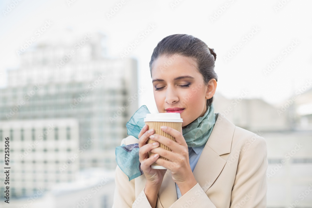 Peaceful smart brown haired businesswoman enjoying coffee Peaceful smart brown haired businesswoman enjoying coffee
