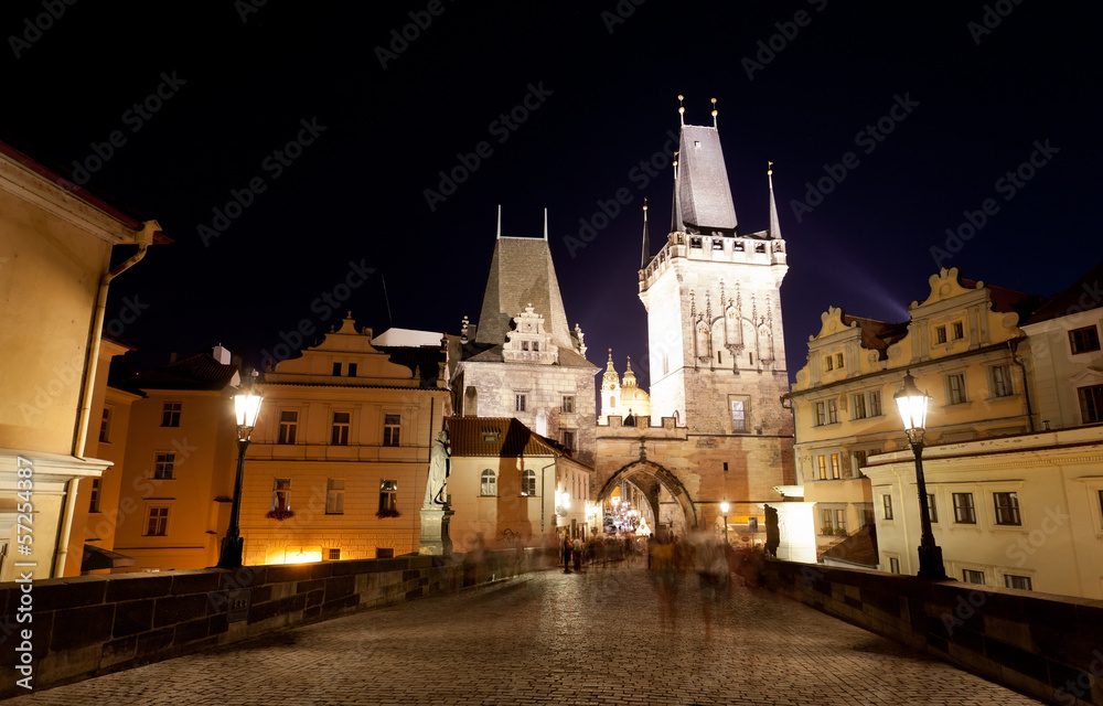 Tourists near Charles bridge in Prague at night.