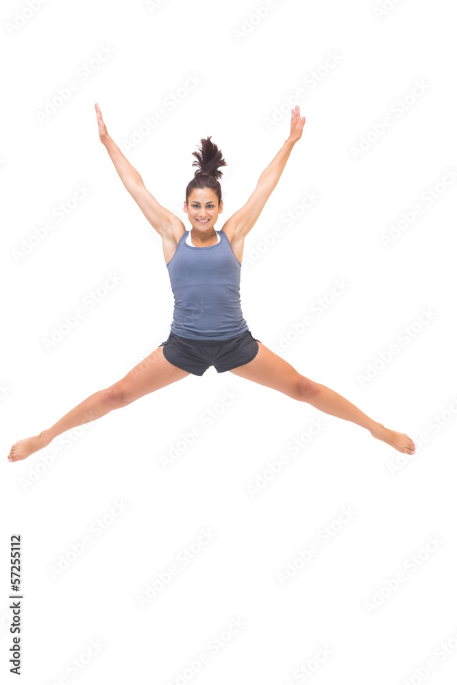 Smiling sporty brunette jumping in the air Smiling sporty brunette jumping in the air