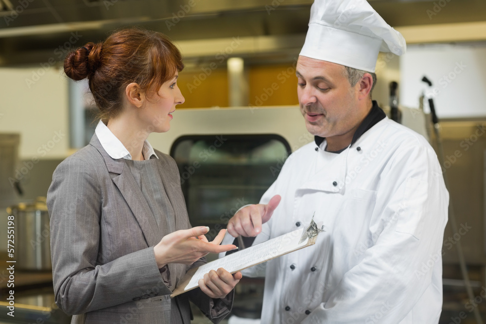 Obraz premium Young female manager talking to the head cook