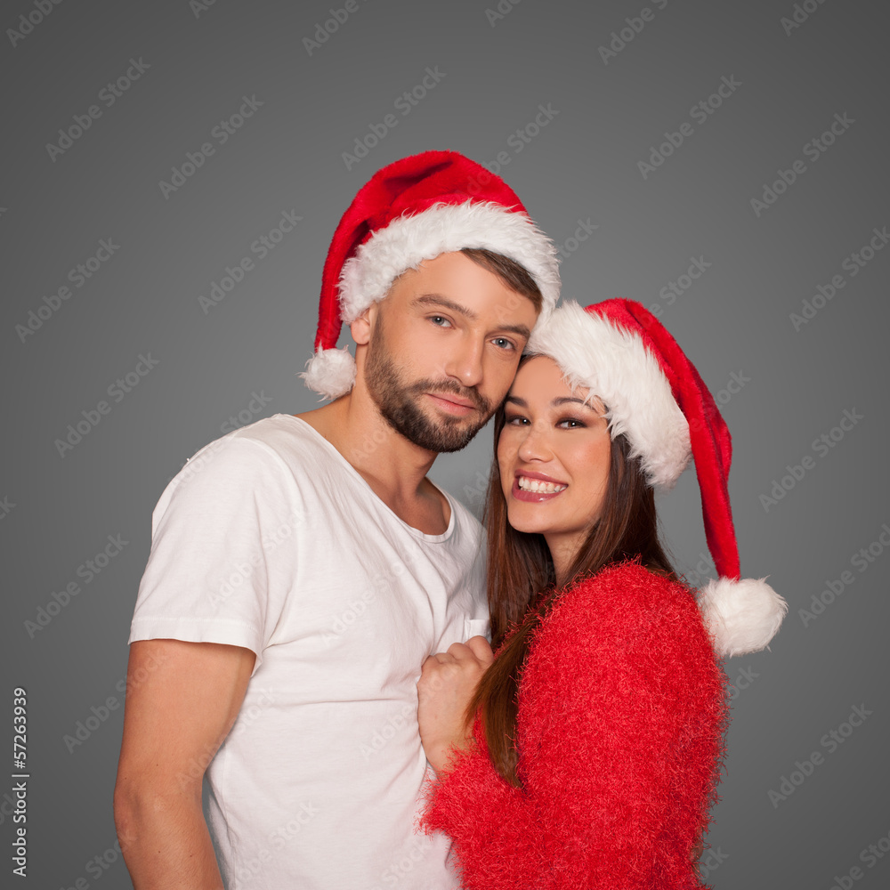 Loving couple wearing Santa hats Loving couple wearing Santa hats