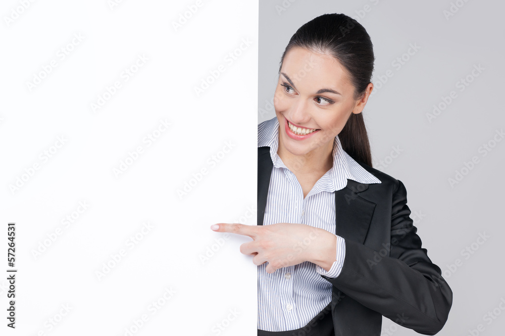 Smiling business woman pointing with finger on blank tablet Smiling business woman pointing with finger on blank tablet