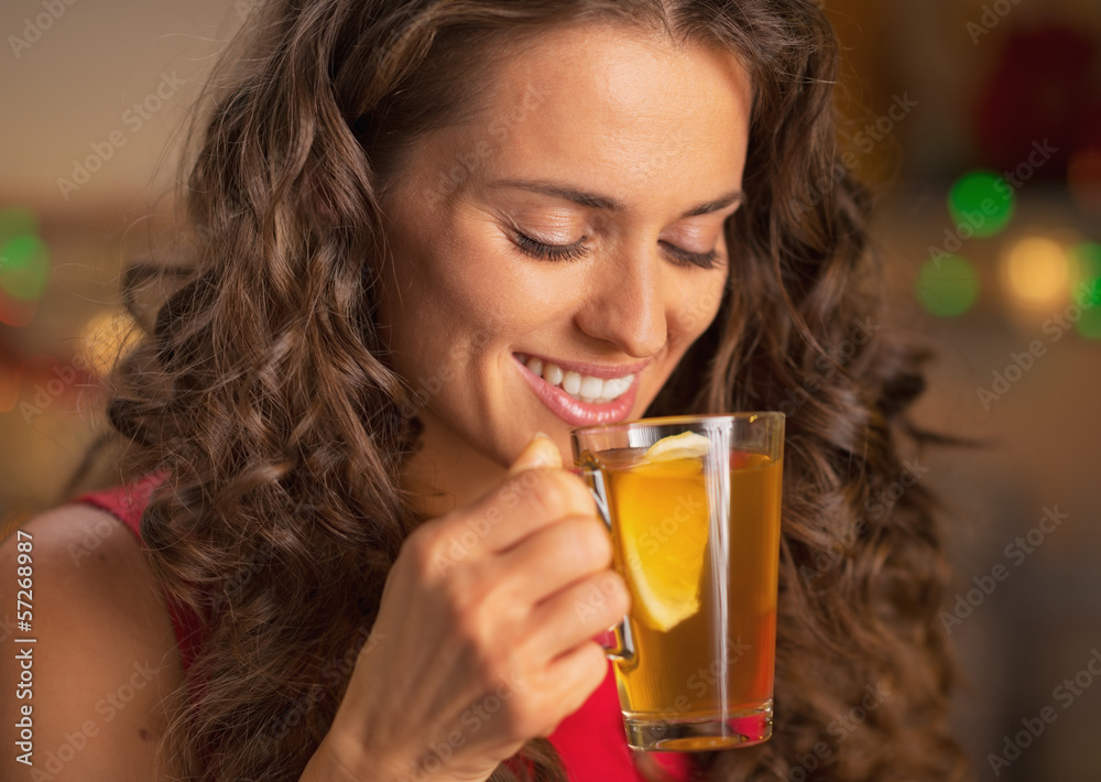 Happy young woman drinking ginger tea with lemon Happy young woman drinking ginger tea with lemon