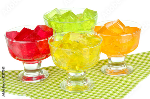 Tasty jelly cubes in bowls on table on white background