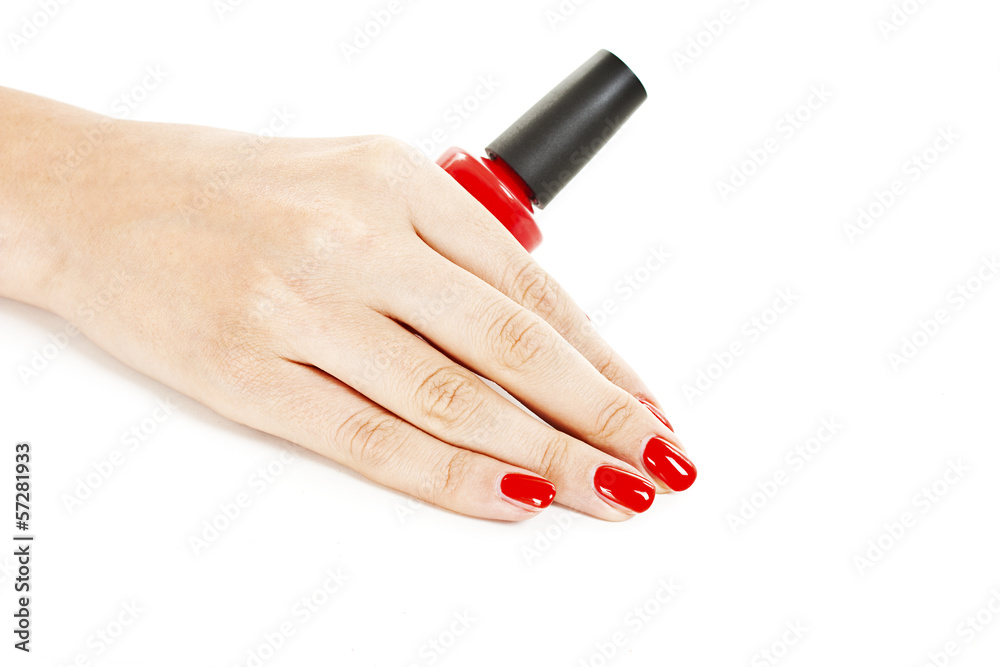 Woman's hand with a bottle of red nail polish