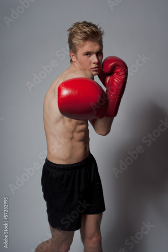 Young blond man with boxing gloves