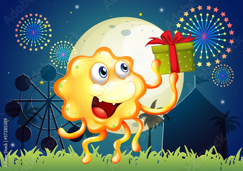 A monster holding a gift in front of the amusement park