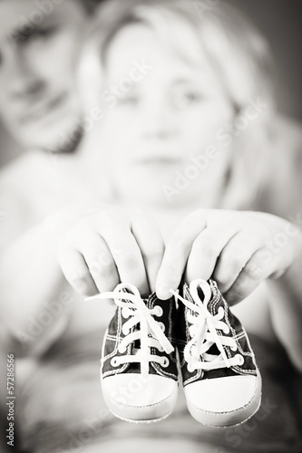 pregnant woman and husband with a child's shoe photo