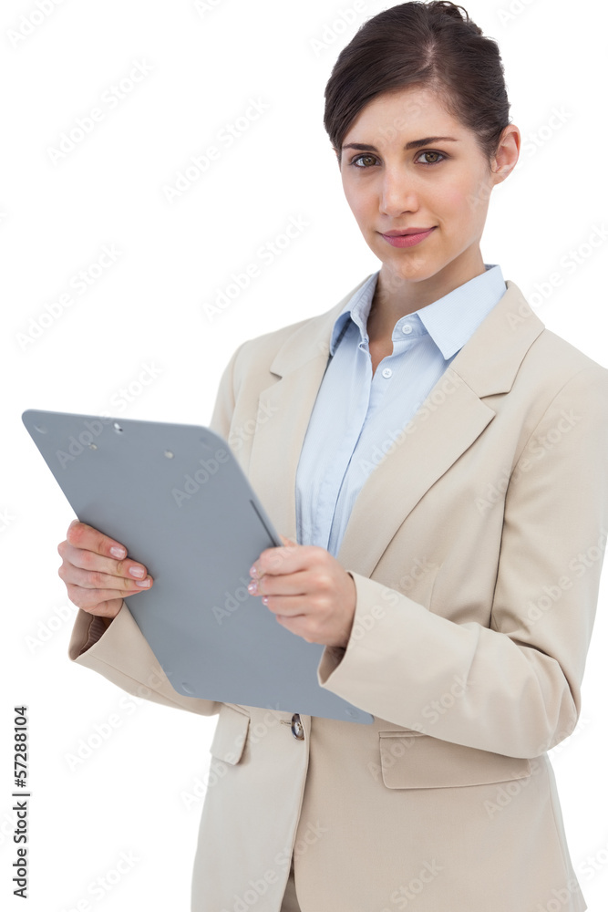 Serious businesswoman with clipboard and looking at camera Serious businesswoman with clipboard and looking at camera