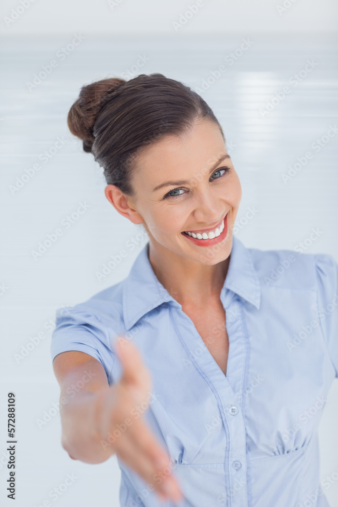 Cheerful businesswoman holding out her hand to camera Cheerful businesswoman holding out her hand to camera