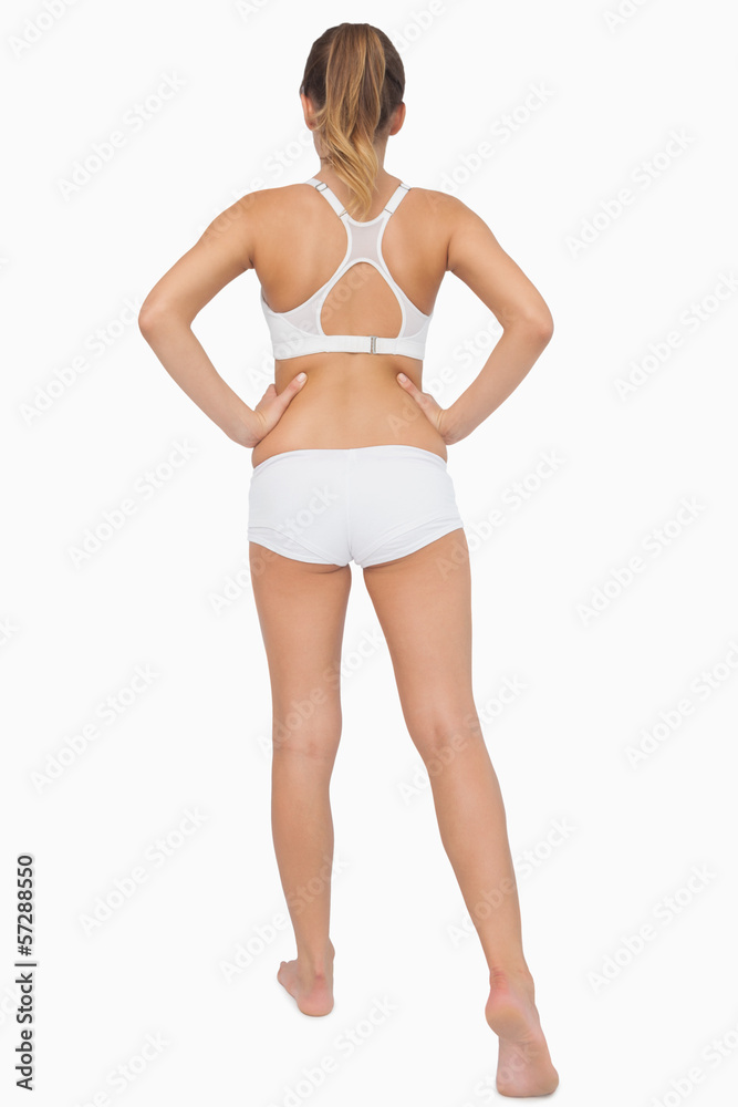 Rear view of ponytailed woman stretching her legs Rear view of ponytailed woman stretching her legs