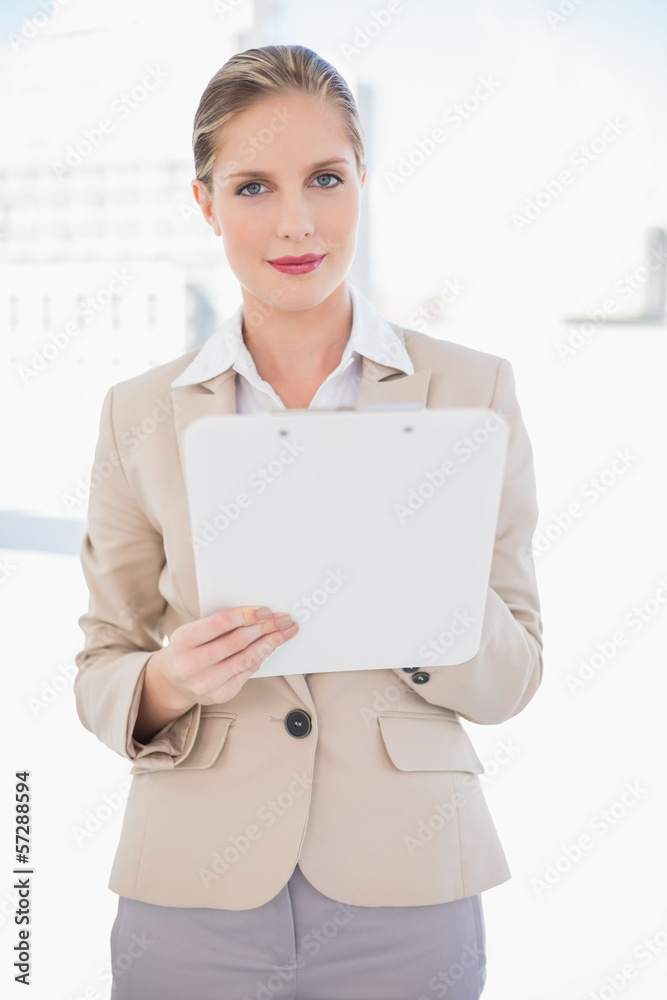 Smiling blonde businesswoman holding clipboard Smiling blonde businesswoman holding clipboard