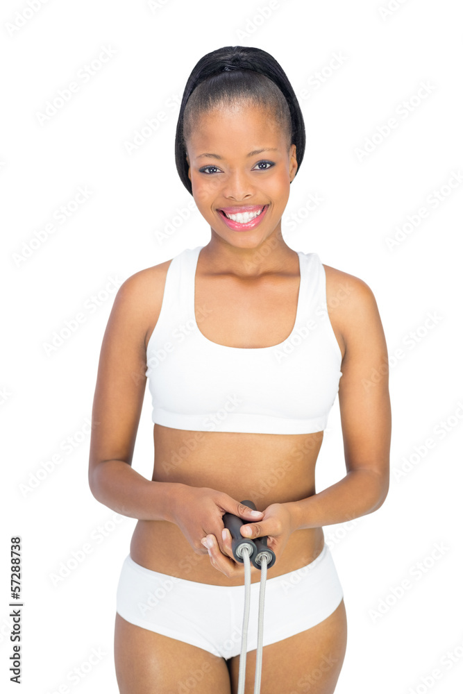 Fit smiling woman in sportswear holding jump rope Fit smiling woman in sportswear holding jump rope