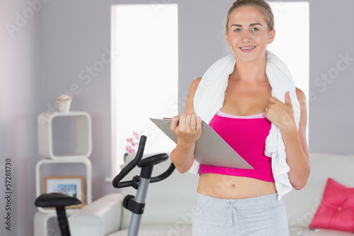Sporty smiling blonde studying clipboard and holding towel © WavebreakMediaMicro