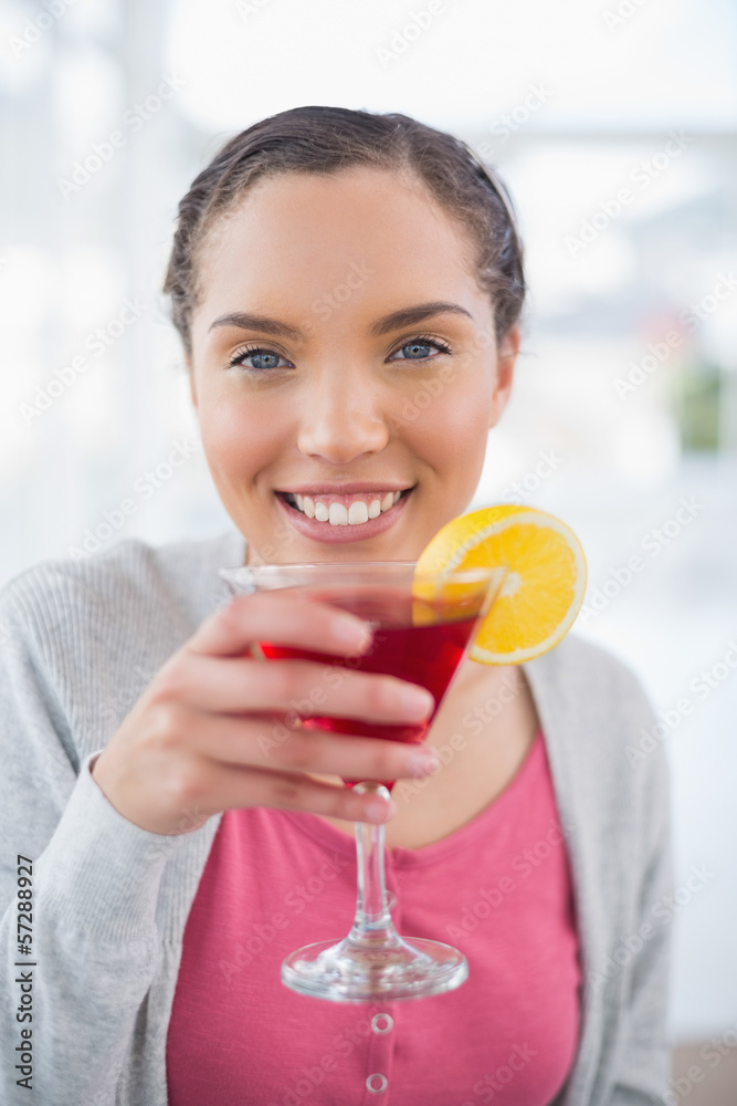 Smiling woman sitting on sofa and drinking cocktail Smiling woman sitting on sofa and drinking cocktail