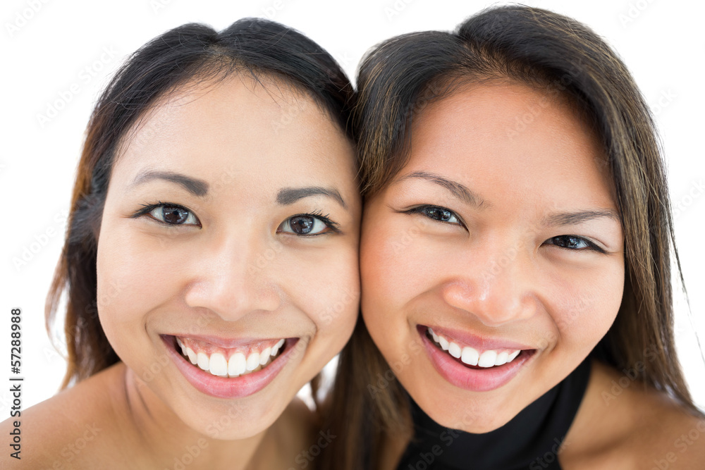 Two happy beautiful sisters smiling at the camera Two happy beautiful sisters smiling at the camera