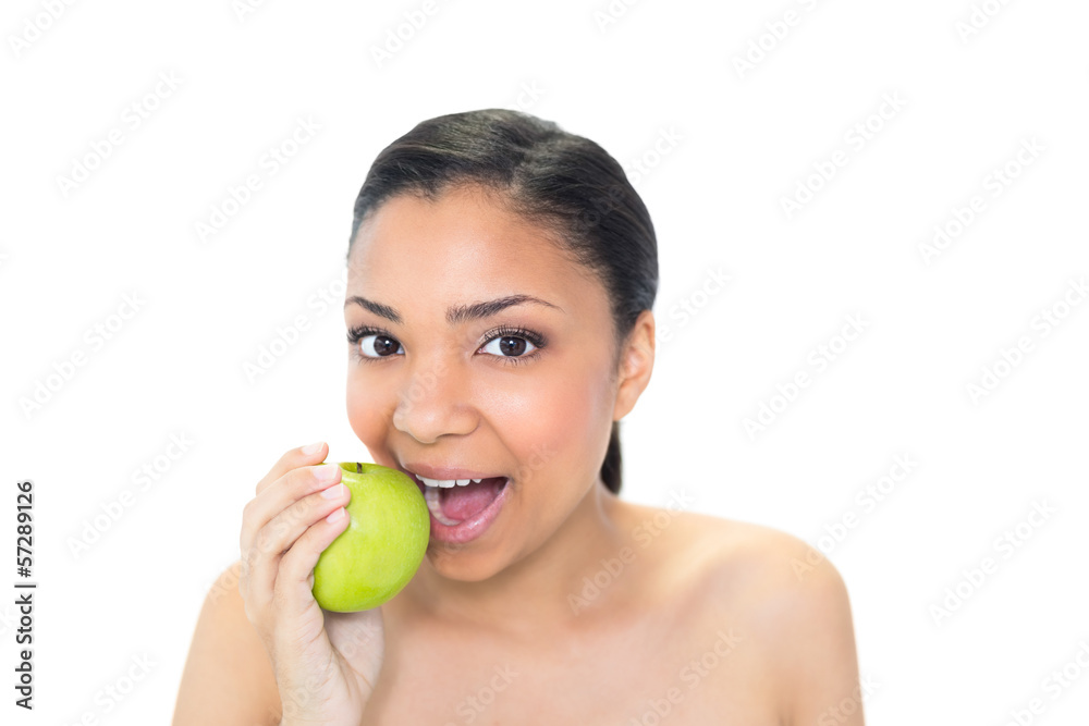Playful young dark haired model eating a green apple Playful young dark haired model eating a green apple