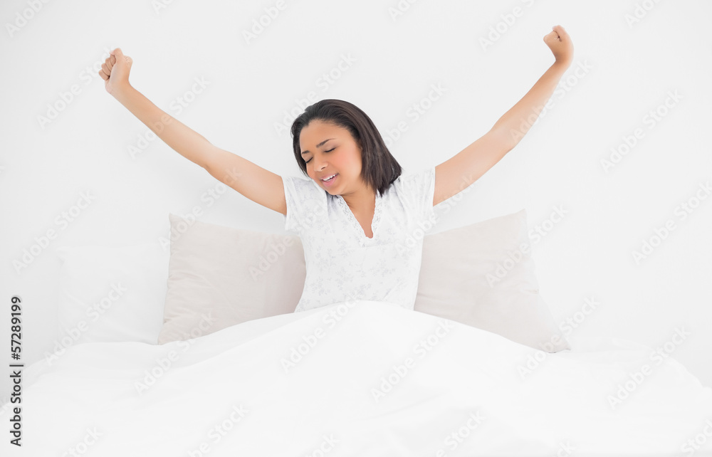 Exhausted young dark haired model stretching in her bed Exhausted young dark haired model stretching in her bed