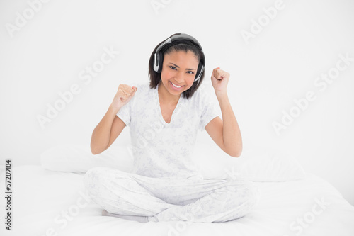 Dynamic young dark haired model listening to music with headphon