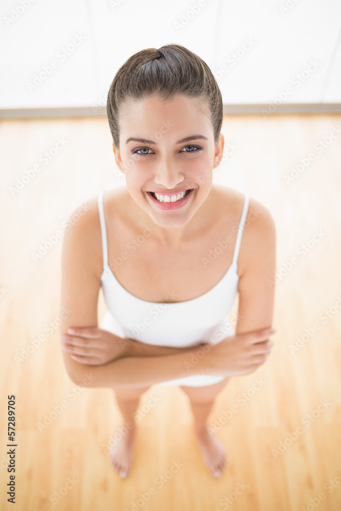 Attractive natural brown haired woman in white sportswear posing