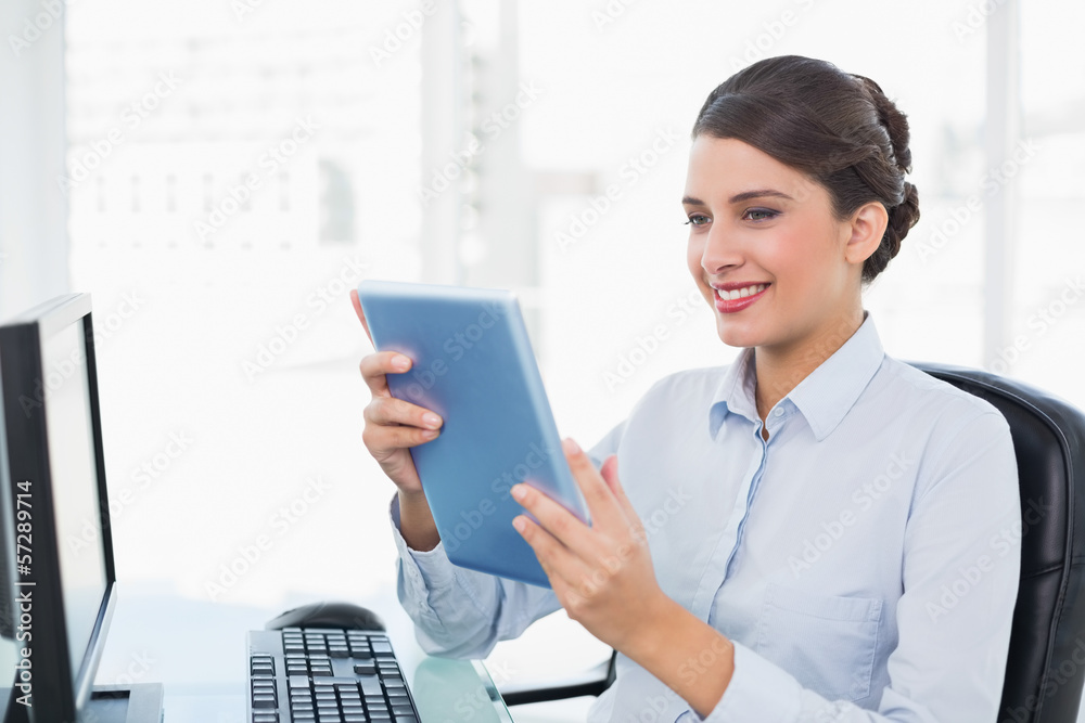 Amused classy brown haired businesswoman using a tablet pc Amused classy brown haired businesswoman using a tablet pc