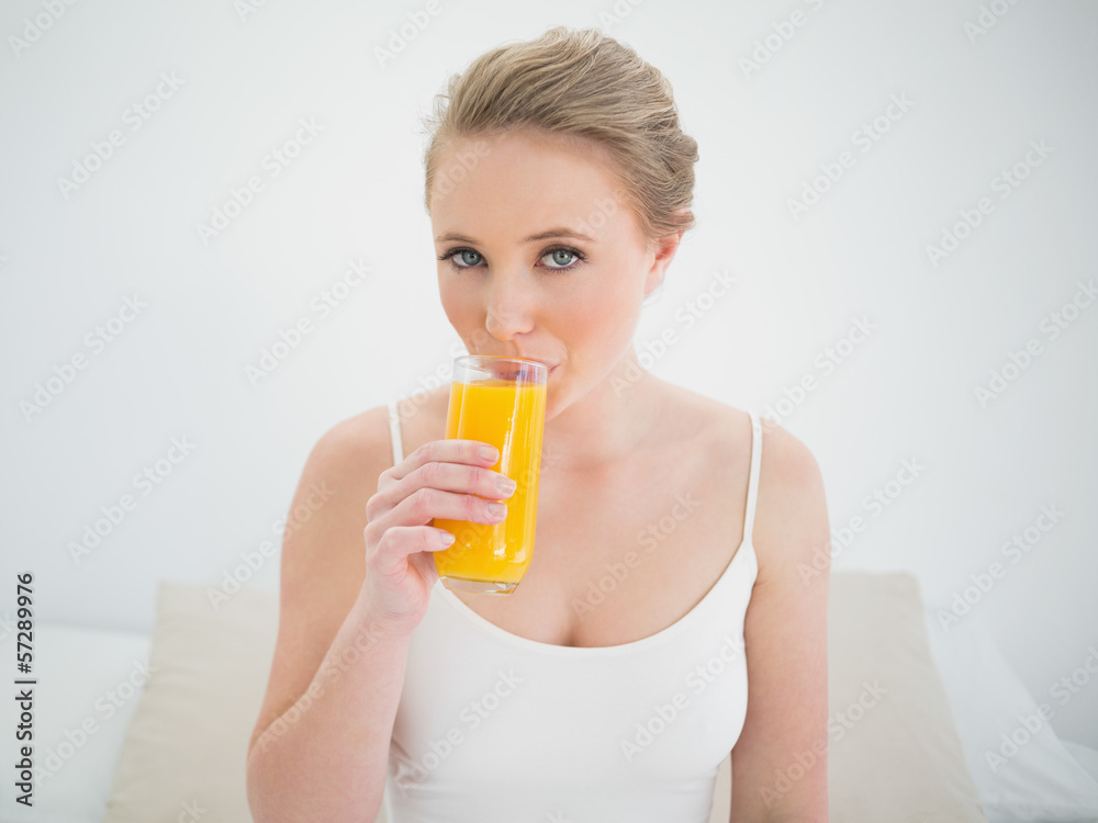 Natural content blonde drinking a glass of orange juice Natural content blonde drinking a glass of orange juice