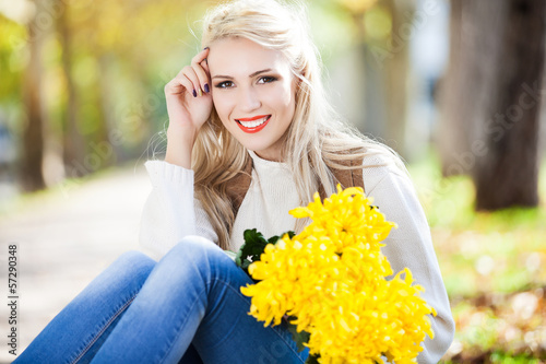 woman with bouquet of flowers in hand in autumn park