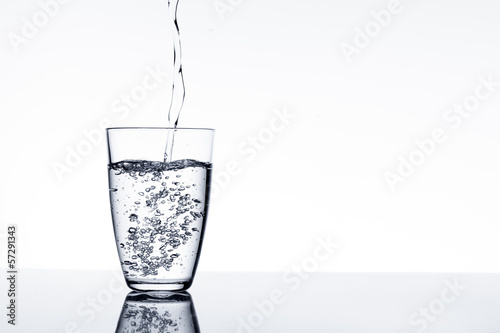 Fotografi moment in which it pours pure sparkling water in a glass
