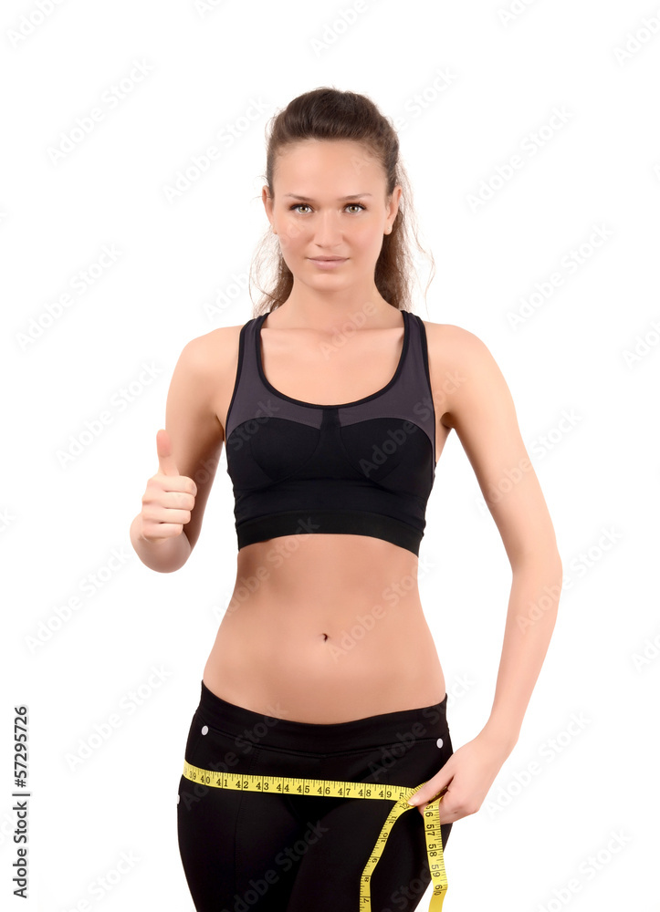 Fit girl measuring her hips and signing thumbs up Fit girl measuring her hips and signing thumbs up