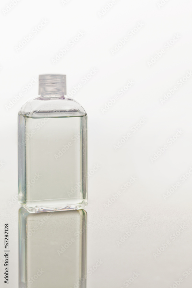 Glass flask on a mirror against white background Glass flask on a mirror against white background