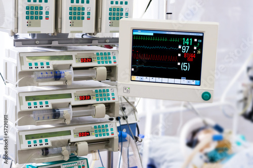 Patient with monitor and infusion pumps in an ICU
