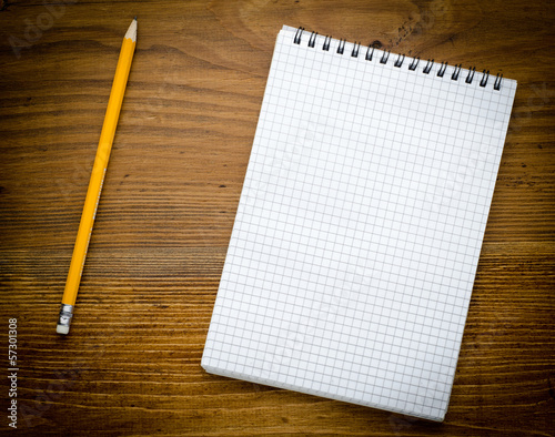 Black notebook with pencile on a wood background photo