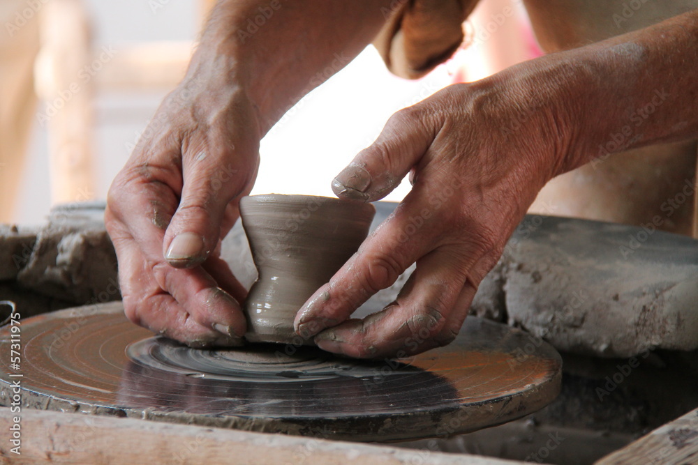 A Clay Pot Being Carefully Lifted from the Potters Wheel. A Clay Pot Being Carefully Lifted from the Potters Wheel.