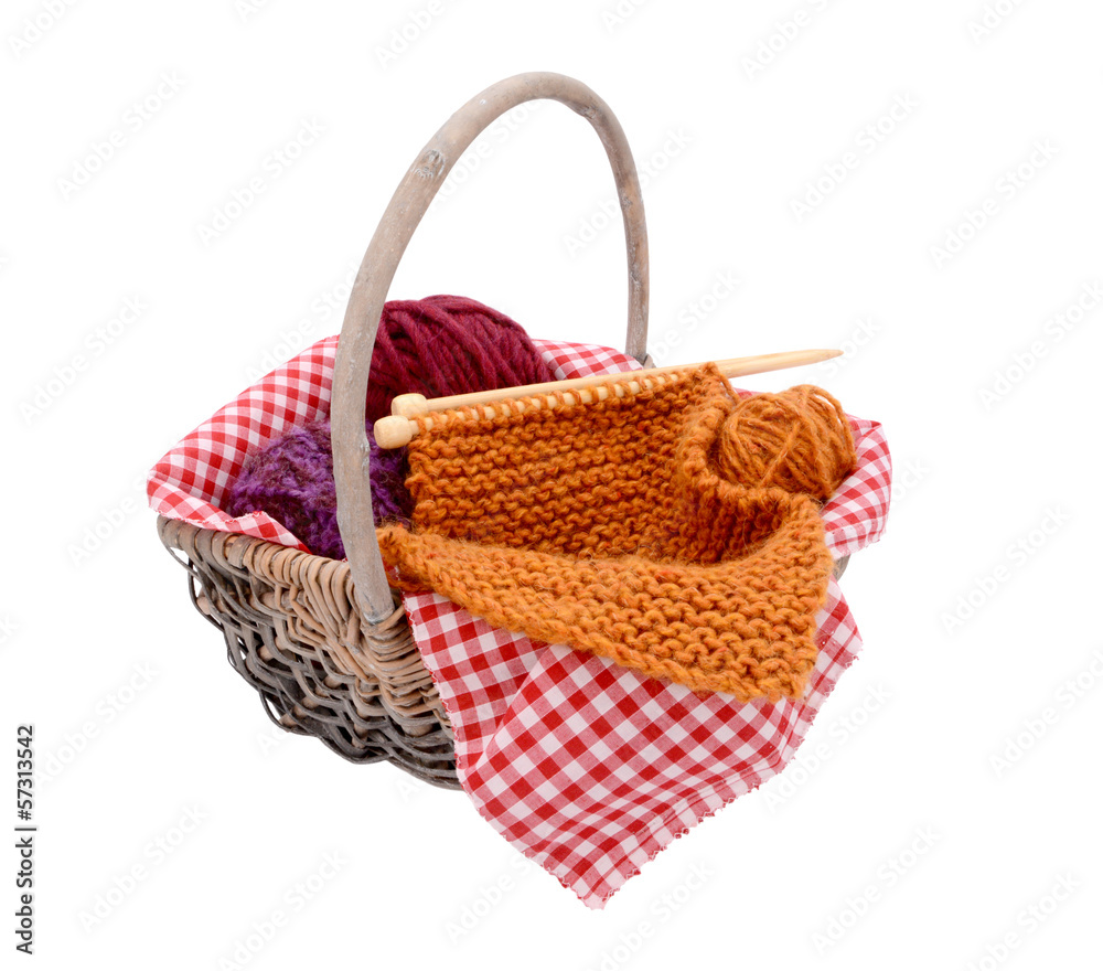 Purple, red and orange wool with knitting in a basket