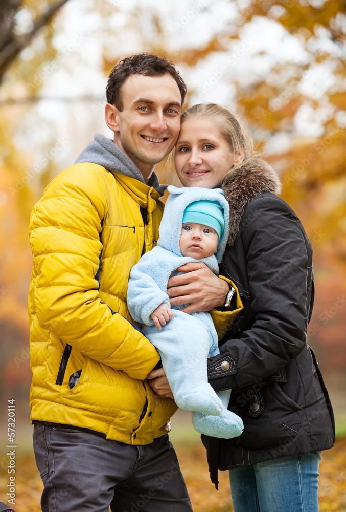 Fototapeta premium Young couple with baby boy in autumn park
