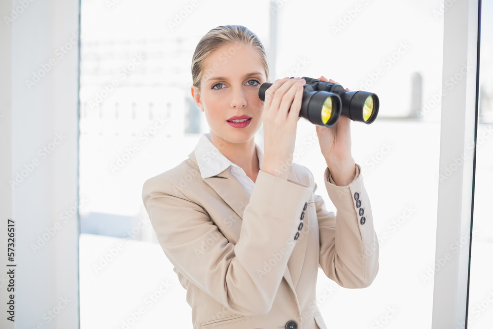 Peaceful blonde businesswoman holding binoculars Peaceful blonde businesswoman holding binoculars