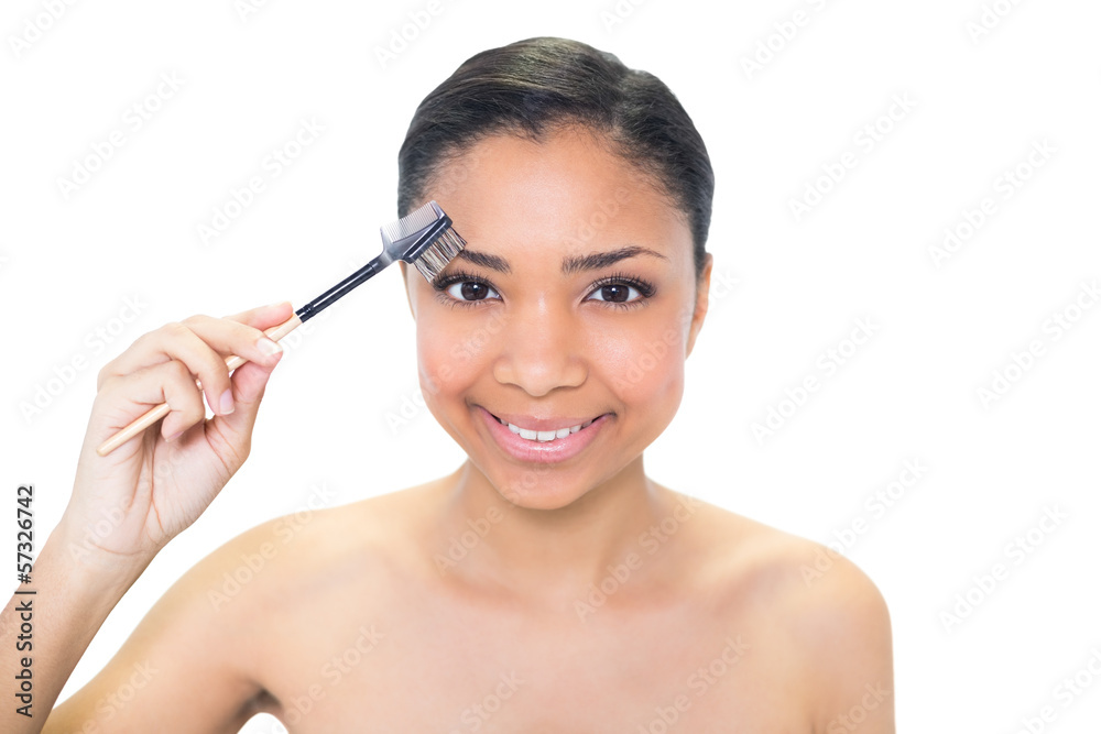 Content young dark haired model brushing her eyebrows Content young dark haired model brushing her eyebrows