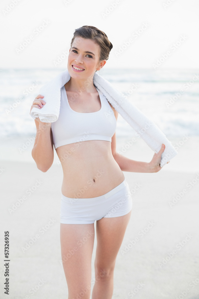 Amused slim brown haired model in white sportswear holding a tow Amused slim brown haired model in white sportswear holding a tow