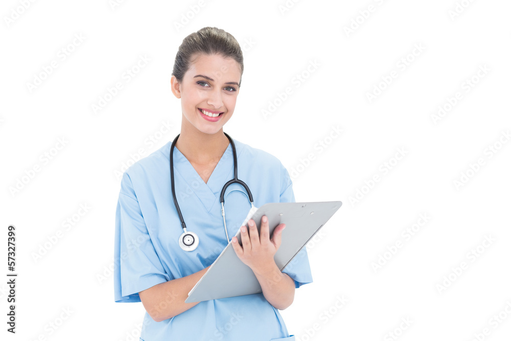 Charming brown haired nurse in blue scrubs checking a report Charming brown haired nurse in blue scrubs checking a report