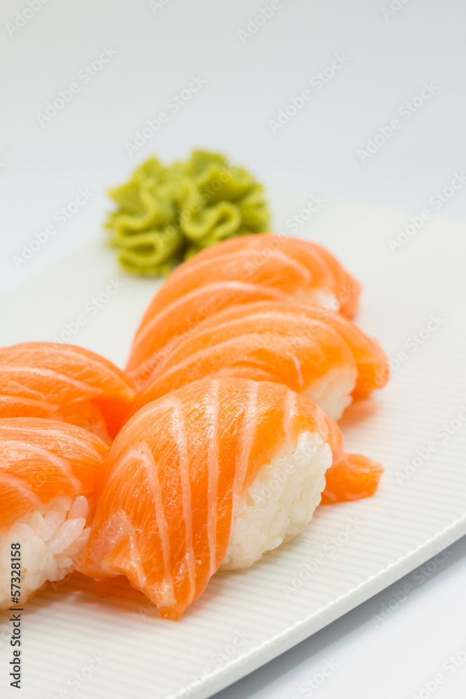 Salmon sushi nigiri on white plate and background with wasabi Salmon sushi nigiri on white plate and background with wasabi
