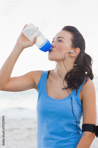 Woman drinking bottled water after doing sports