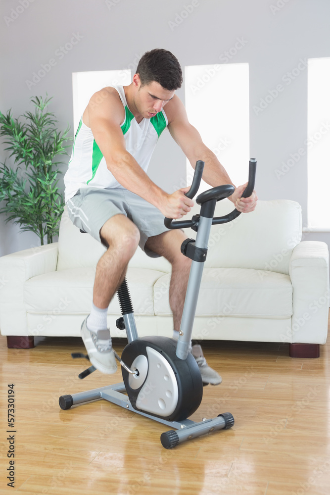 Sporty handsome man training on exercise bike Sporty handsome man training on exercise bike