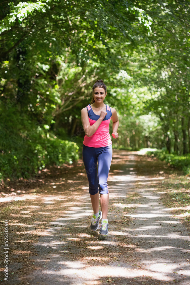 Lovely young woman jogging towards camera Lovely young woman jogging towards camera