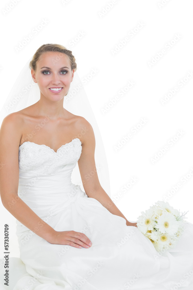 Cheerful young bride sitting on floor