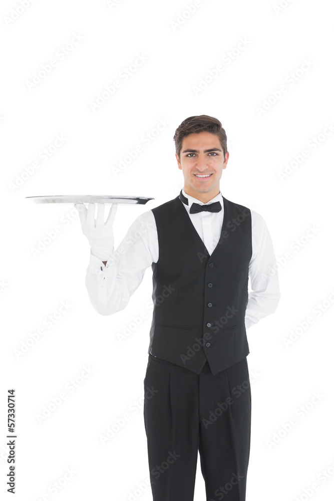 Cheerful young waiter showing an empty silver tray Cheerful young waiter showing an empty silver tray